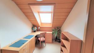 an attic office with a desk and a window at Ferienwohnung am Schwarzwaldrand in Nagold