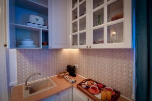 a kitchen with white cabinets and a sink at Casa Barițiu in Braşov +55 photos