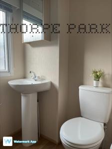 a bathroom with a white toilet and a sink at Caravan Holiday on Haven site in Cleethorpes