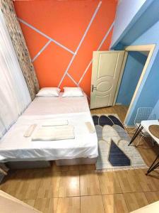 una piccola camera con un letto con una parete arancione di İstanbulun merkezinde,şık,büyük 2+1 dubleks daire a Istanbul