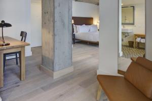 a room with a bed and a table with a couch at Boro Hotel in Queens