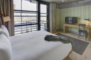 a bedroom with a large white bed with a large window at Boro Hotel in Queens