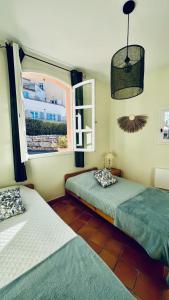 濱海聖西的住宿－HAMEAU DES AMANDIERS VUE MER - PISCINE, GOLF et TENNIS PRIVE，一间卧室设有两张床和窗户。