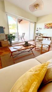 sala de estar con sofá y mesa en HAMEAU DES AMANDIERS VUE MER - PISCINE, GOLF et TENNIS PRIVE, en Saint-Cyr-sur-Mer