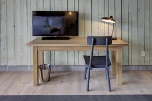 a desk with a chair and a television on it at Boro Hotel in Queens
