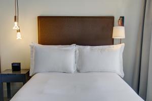 a bed with white pillows in a hotel room at Boro Hotel in Queens