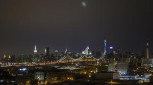 a view of a city at night with a bridge at Boro Hotel in Queens