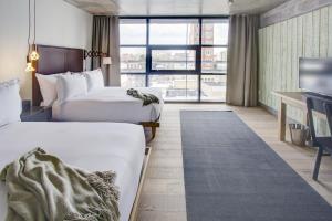 a hotel room with two beds and a tv at Boro Hotel in Queens