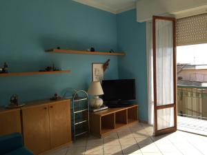 a living room with blue walls and a television at Vacanze a Finale Ligure in Finale Ligure