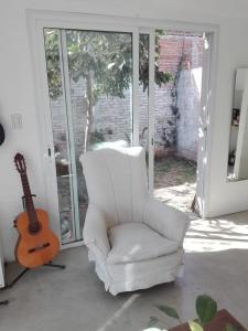 una silla blanca y una guitarra en la sala de estar en Mussa en Salta