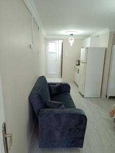 a living room with a blue couch and a refrigerator at Ava suite teras in Istanbul