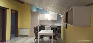 a small kitchen with a white table and chairs at Hostal San Antonio in Iscar