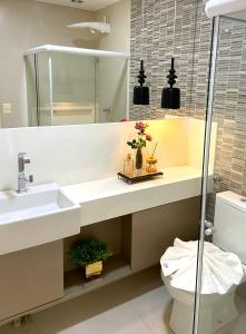 a bathroom with a sink and a toilet at Barra Bali, com incrível vista para o mar! - Destino BSM 209 in Barra de São Miguel