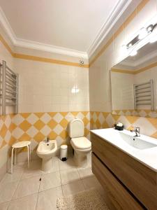 een badkamer met een toilet, een wastafel en een spiegel bij Sun & Wave Apartment in Peniche