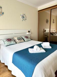 een slaapkamer met een groot bed en handdoeken bij Sun & Wave Apartment in Peniche