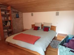 a bedroom with a large bed with red pillows at La maison neuve in Fontaines