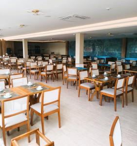 uma sala de jantar com mesas e cadeiras de madeira em Aqualand Park & Resort Oficial em Salinópolis