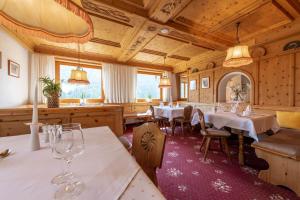 a dining room with white tables and chairs at Hotel Stilfserhof in Stelvio