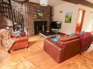 a living room with two couches and a fireplace at Bolland Hall in Morpeth