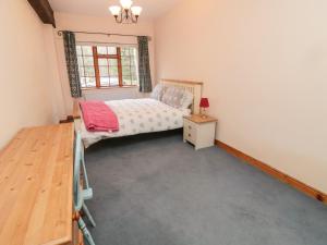 1 dormitorio con 1 cama, mesita de noche y ventana en Bolland Hall, en Morpeth