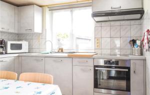 a kitchen with white cabinets and a sink and a stove at Jessica in Ciney