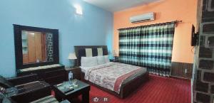 um quarto de hotel com uma cama e um sofá em Mulberry Guest House F-10 em Islamabad