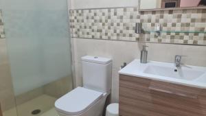 een badkamer met een wit toilet en een wastafel bij La Casilla de Nerja in Nerja +8 foto's