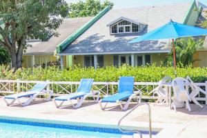 a group of chairs and an umbrella next to a pool at Condo Rios Resort in Ocho Rios