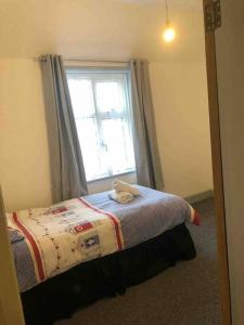 Dormitorio pequeño con cama y ventana en 4 Bedroom School House, en Holt