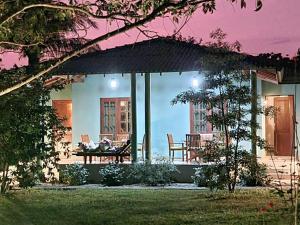 a house with a porch with a table and chairs at Green villa yala in Tissamaharama