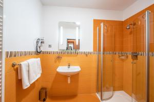 a bathroom with a sink and a shower at Penzion a Restaurant Barbora in Kutná Hora