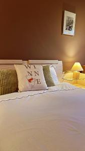 a white bed with a pillow with the words winnipeg at اسكن في وسط مدينة لندن الكبرى Live in the midst of the sights اسكن في وسط مدينة لندن الكبرى in London