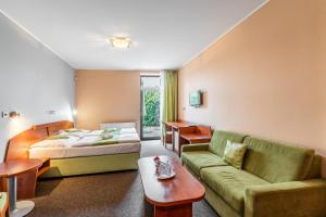 a hotel room with a bed and a couch at Penzion a Restaurant Barbora in Kutná Hora