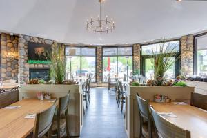 a restaurant with wooden tables and chairs and windows at Chateau Canmore in Canmore