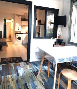 Il comprend un salon avec une table blanche et une cuisine. dans l'établissement T2-3 cabine Les YUCCAS 200 m plage du Boucanet Rive Droite Grau du Roi idéal 2-4 pers, au Grau-du-Roi