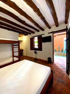a bedroom with a large bed and a window at Hotel Tierra Roja By MH in Barichara