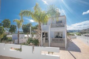 una casa blanca con palmeras delante en Tonia Seaview Villas, en Protaras