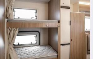 a small room with two windows in an rv at Campervan and Motorhome Hire Isle of Man in Kirk Braddon