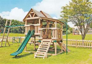 a wooden playground with a slide and a swing at Tamar Valley, Cornwall in Callington