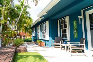 een blauw huis met stoelen en een tafel ervoor bij Modern Oasis in Fort Lauderdale