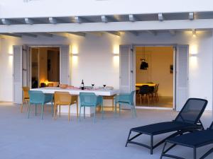 um pátio com uma mesa e cadeiras e uma sala de jantar em Villa Aura em Kastraki