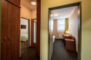 a hotel room with a bathroom and a bedroom at Penzion a Restaurant Barbora in Kutná Hora