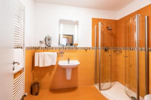 a bathroom with a sink and a shower at Penzion a Restaurant Barbora in Kutná Hora