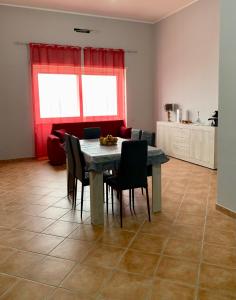 sala de estar con mesa, sillas y sofá en Casa Vacanze Formia, en Formia