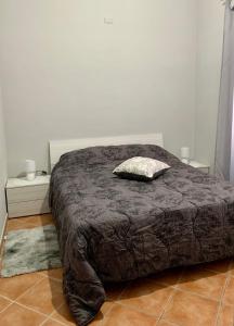 łóżko z brązową kołdrą w sypialni w obiekcie Casa Vacanze Formia w mieście Formia