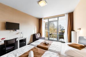 a hotel room with two beds and a window at Penzion a Restaurant Barbora in Kutná Hora