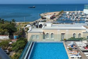 a house with a swimming pool in front of a marina at Luxuriöses Appartement mit Pool in Gaira