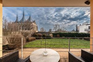 a table on a balcony with a view of a castle at Penzion a Restaurant Barbora in Kutná Hora