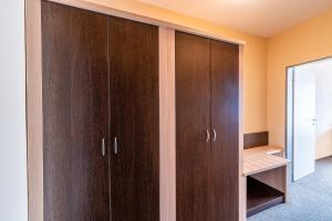 a closet with wooden cabinets in a room at Penzion a Restaurant Barbora in Kutná Hora