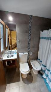 y baño con aseo, lavabo y espejo. en La casa de Yala en San Salvador de Jujuy